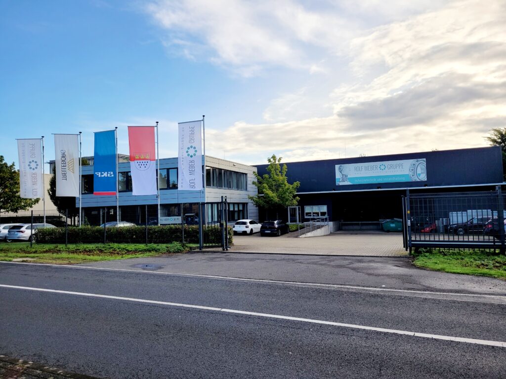 Standort WEBER Köln Außenansicht gesamtes Gebäude mit Einfahrtstor und Verwaltung
